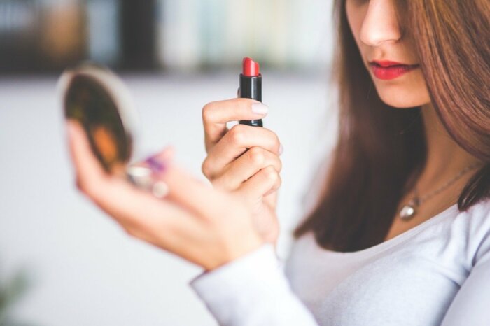 Girl putting her lipstick on