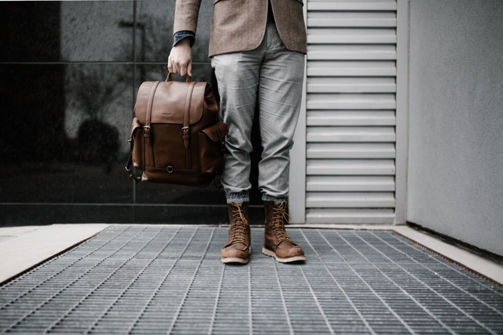 young man waiting and holding a bag