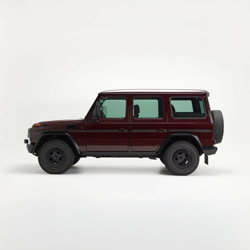Side profile of the restored 1998 Mercedes-Benz G320 with black wheels and all-terrain tyres